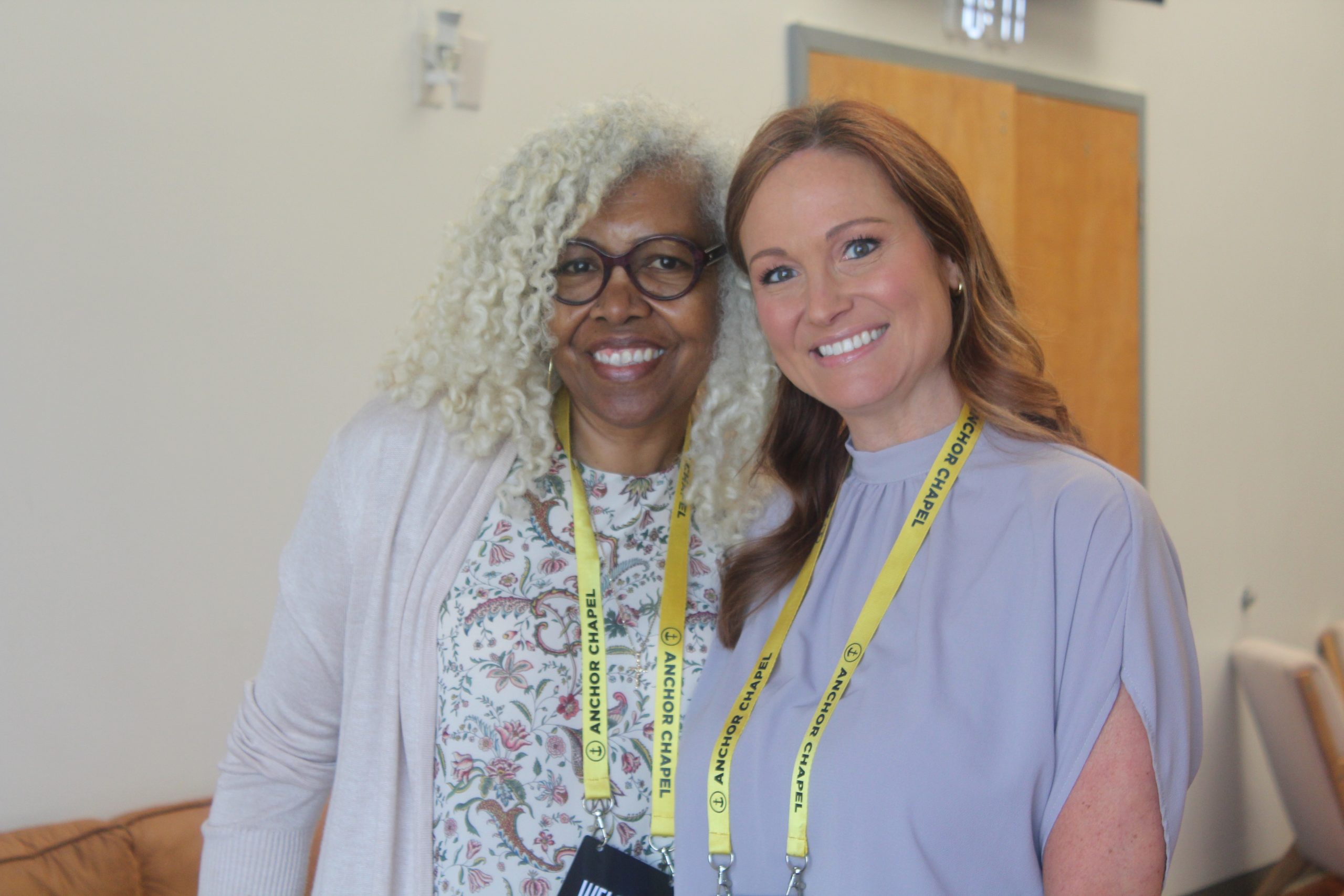 Two smiling Anchor Chapel members at church