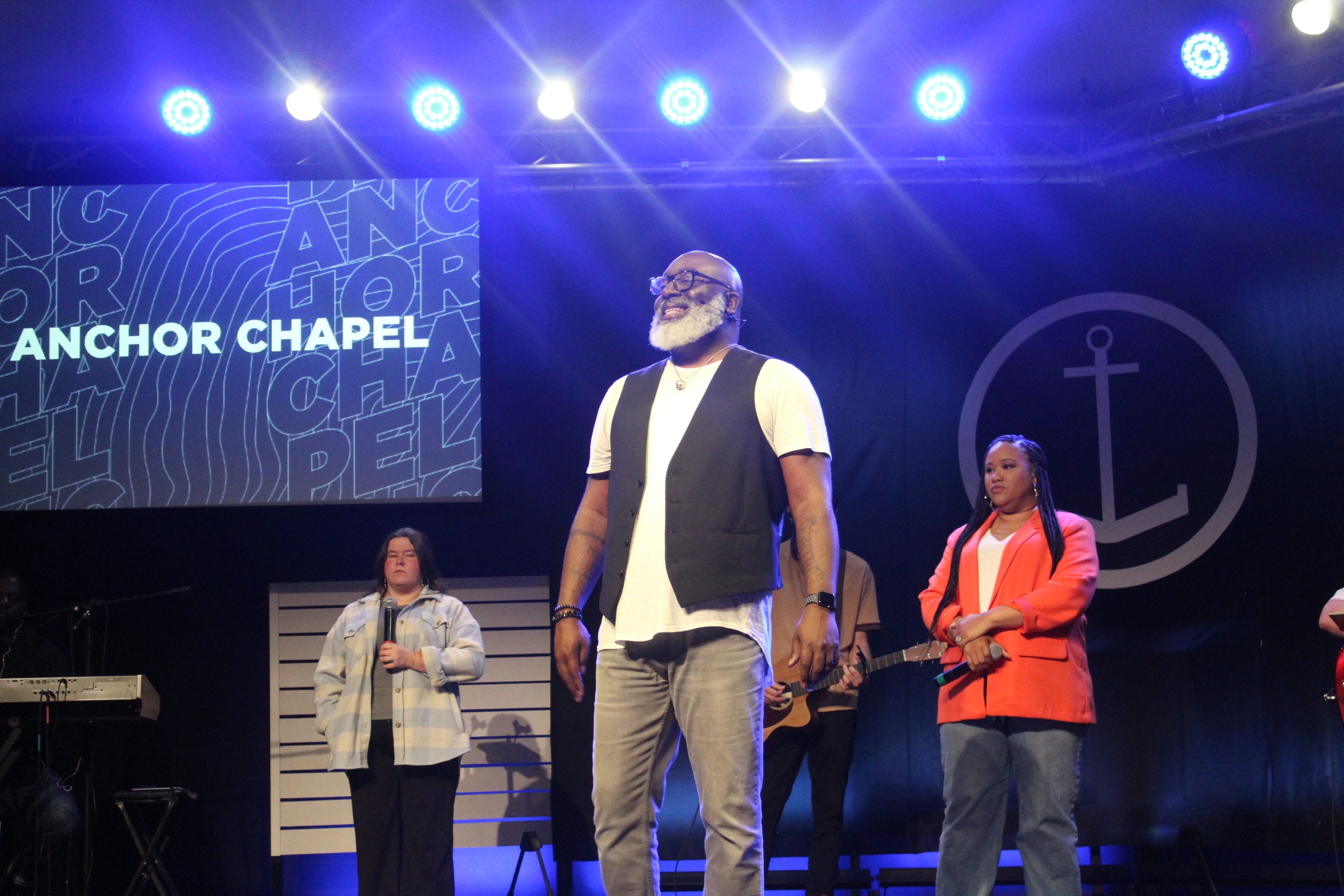 Anchor Chapel pastor speaking on stage with the worship team